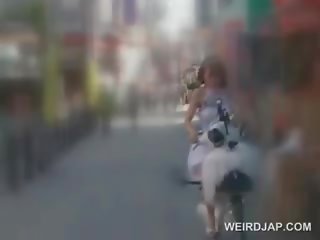 Aasia teismeline nukk saamine tussu märg kuigi ratsutamine a bike